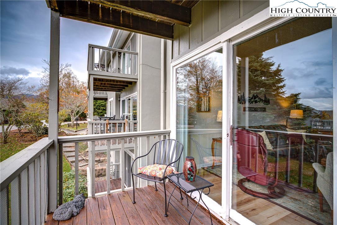 367 Skyleaf Drive, Unit D8 Banner Elk, NC 28604 - Photo 35 of 43 a view of a balcony with wooden floor and outdoor seating