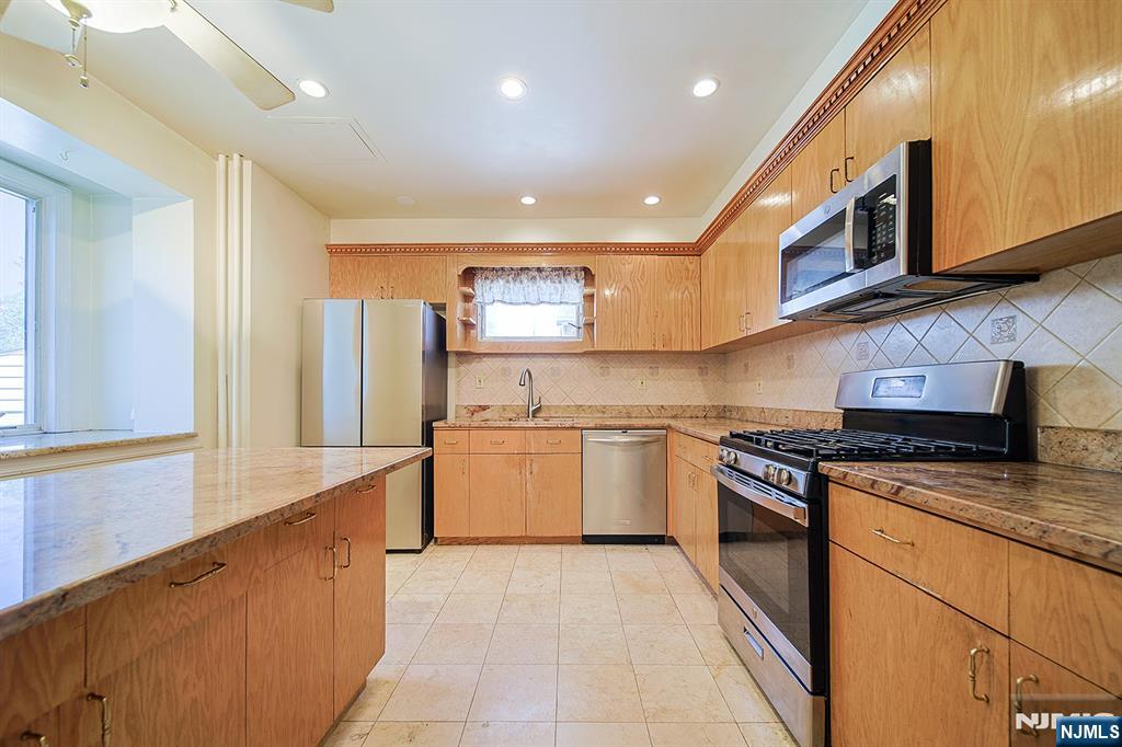 1585 Bergen Boulevard Leonia, NJ 07605 - Photo 26 of 50 a kitchen with stainless steel appliances granite countertop a stove a sink and a microwave