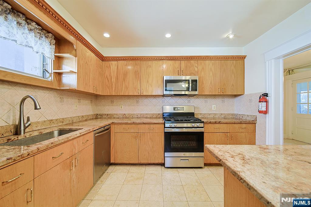1585 Bergen Boulevard Leonia, NJ 07605 - Photo 29 of 50 a kitchen with stainless steel appliances granite countertop a stove sink and cabinets