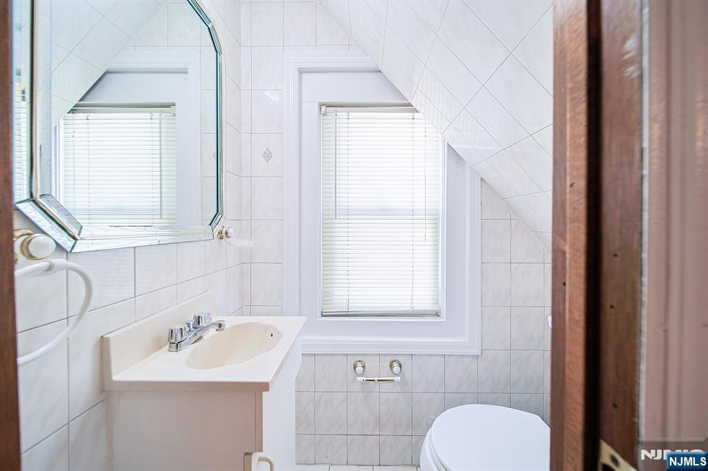 1585 Bergen Boulevard Leonia, NJ 07605 - Photo 32 of 50 a bathroom with a toilet sink a mirror and window