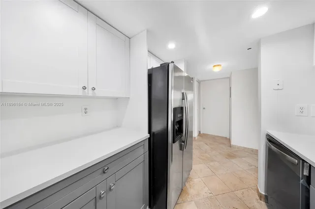 a kitchen with a sink a counter top space stainless steel appliances and cabinets