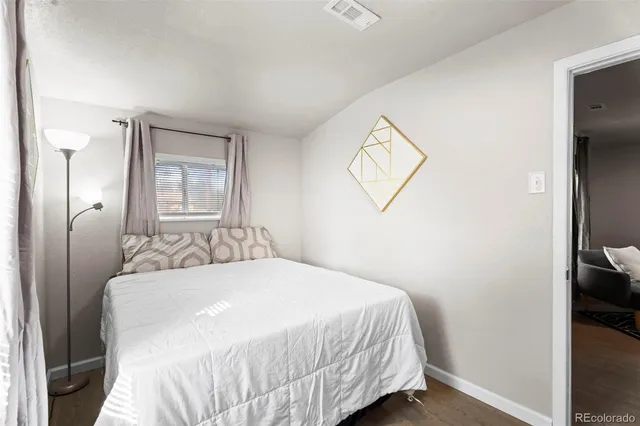 a bedroom with a bed and a painting on the wall