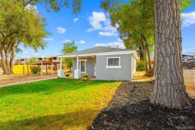 a view of a house with backyard and a tree