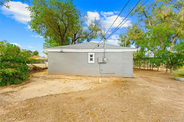 a view of a house with a yard and a large tree