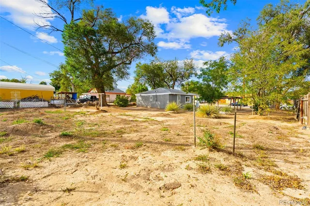 a aerial view of a house with swimming pool next to a big yard