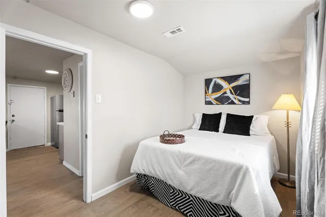 a bedroom with a bed and painting on the wall