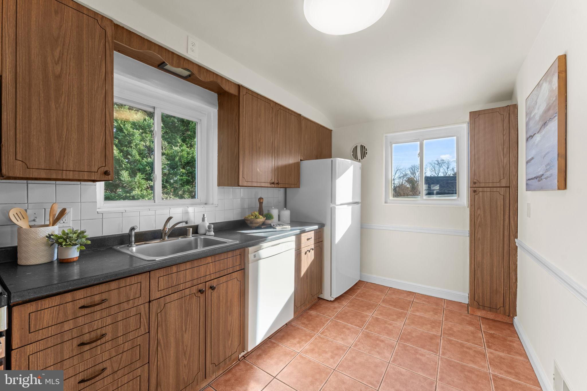 11013 Amherst Avenue Silver Spring, MD 20902 - Photo 11 of 74 a kitchen with stainless steel appliances granite countertop a sink stove and refrigerator