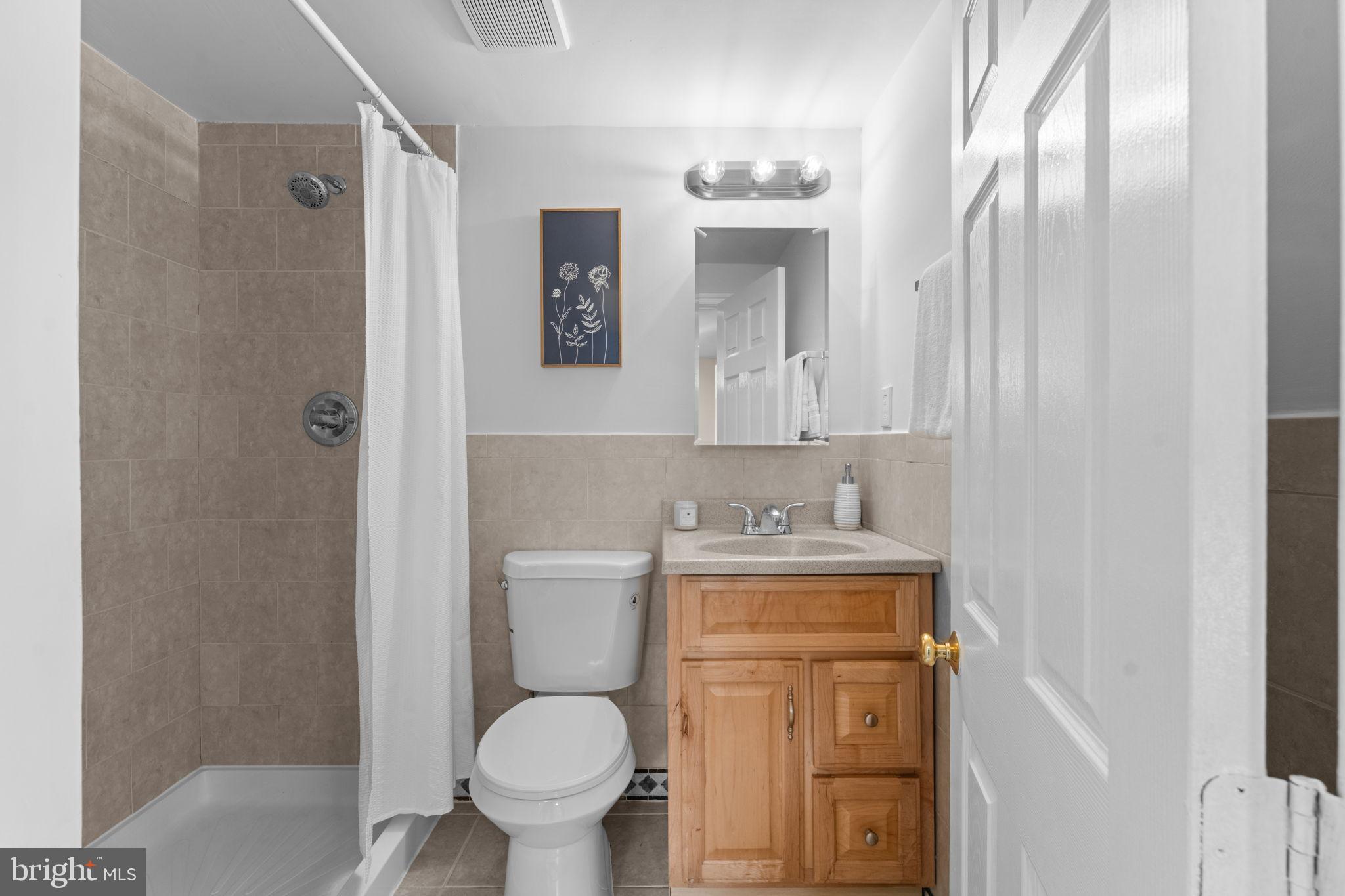 11013 Amherst Avenue Silver Spring, MD 20902 - Photo 33 of 74 a bathroom with a granite countertop toilet a mirror and a sink