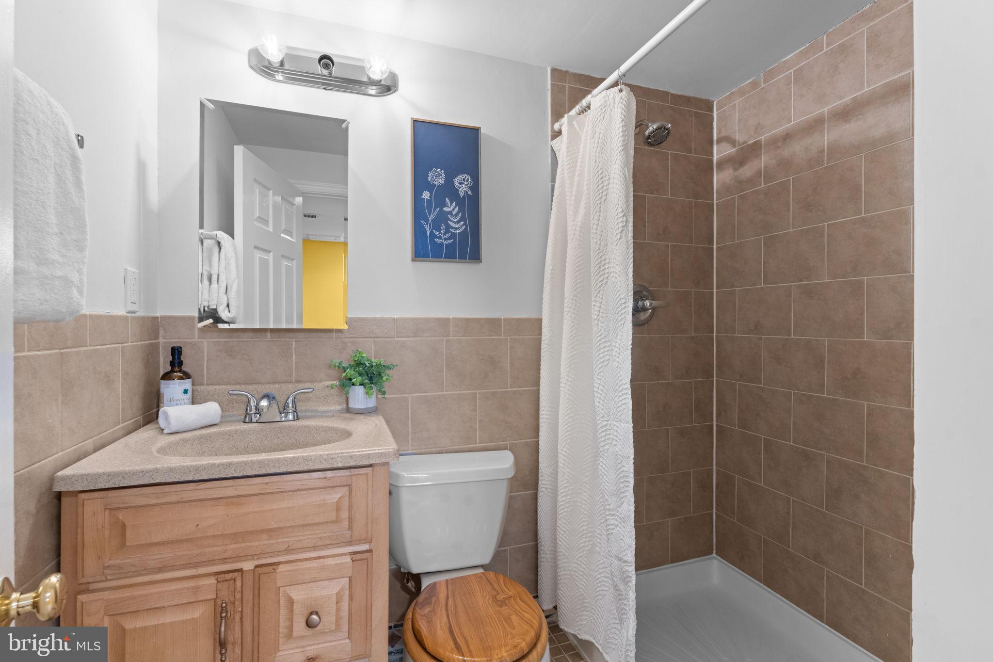 11013 Amherst Avenue Silver Spring, MD 20902 - Photo 42 of 74 a bathroom with a sink toilet vanity and shower