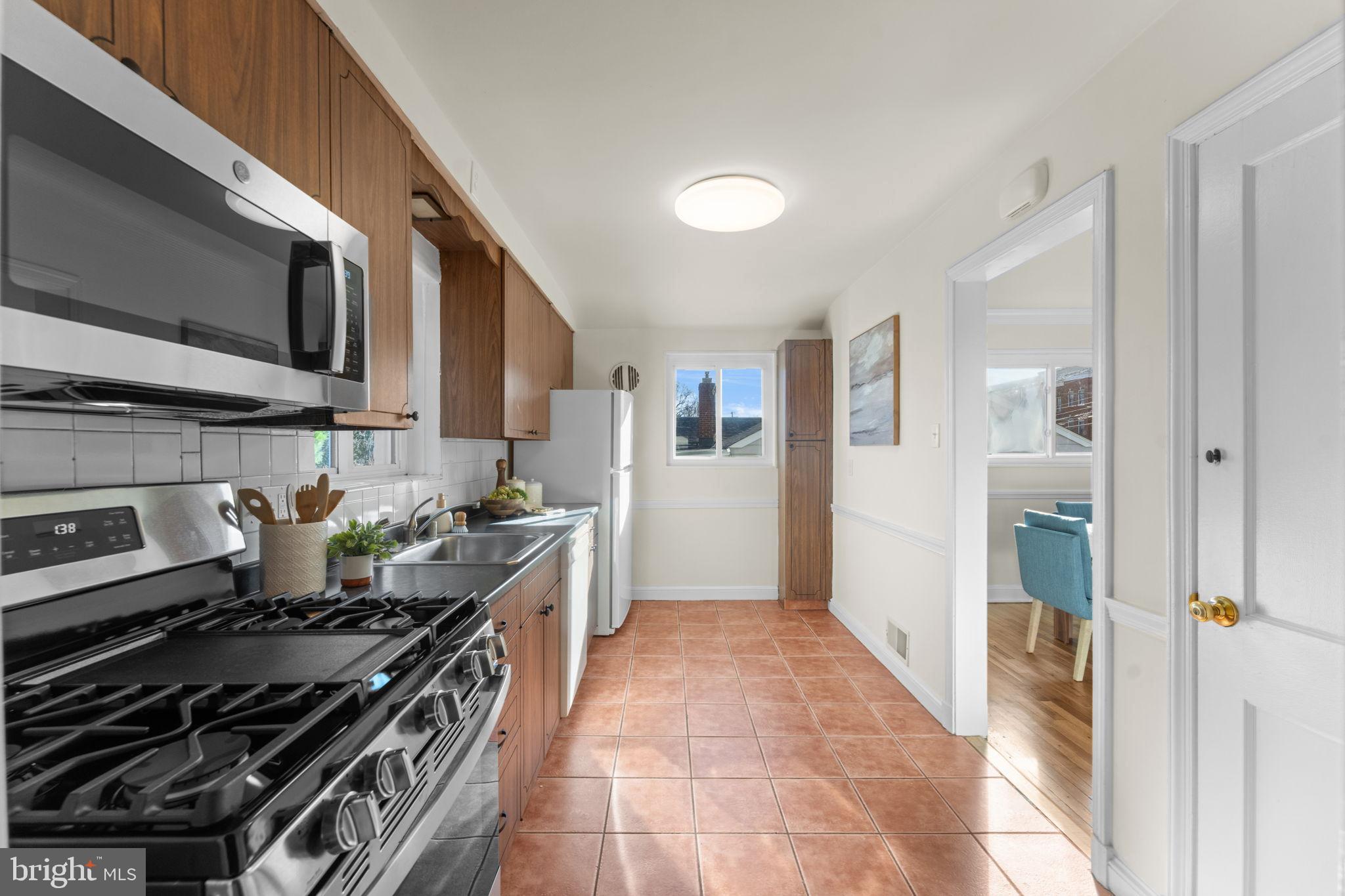 11013 Amherst Avenue Silver Spring, MD 20902 - Photo 10 of 74 a kitchen with granite countertop a stove and a refrigerator