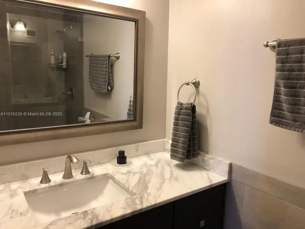 a bathroom with a granite countertop sink and a mirror
