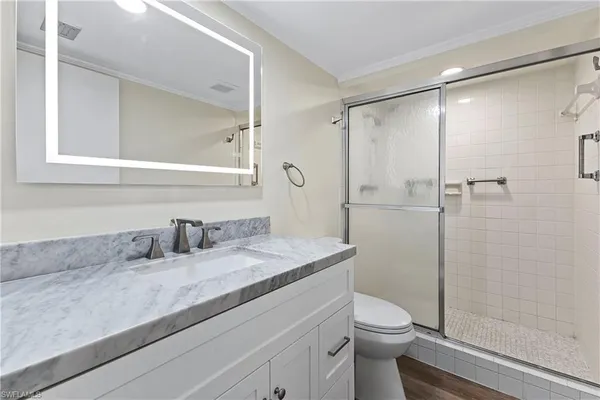 a bathroom with a granite countertop sink toilet and shower