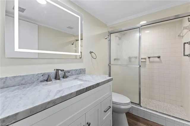 a bathroom with a granite countertop sink toilet and shower