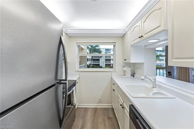 a kitchen with a sink a window and appliances