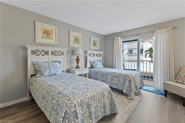 a bedroom with two beds and a large window