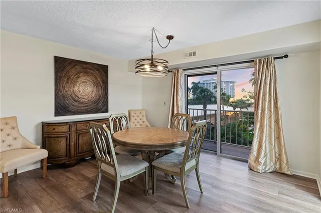 a dining room with furniture a chandelier and wooden floor