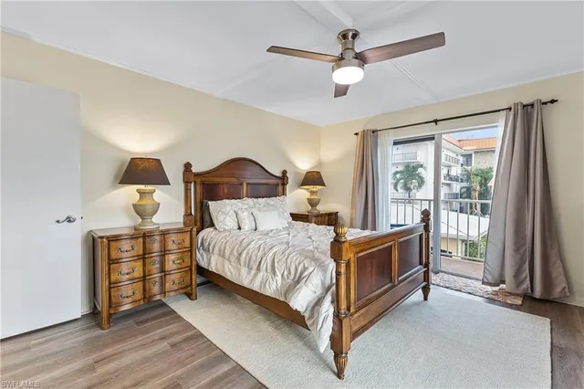 a bedroom with a large bed and a chandelier fan