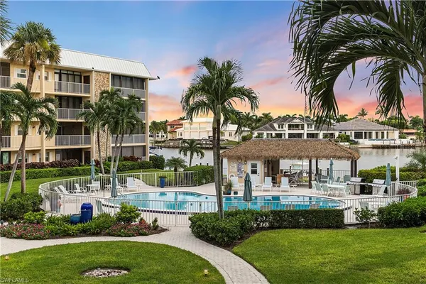a front view of a house with a garden and swimming pool