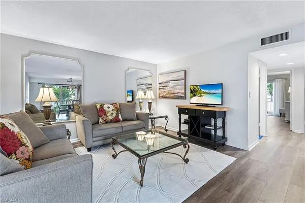 a living room with furniture a rug and a flat screen tv