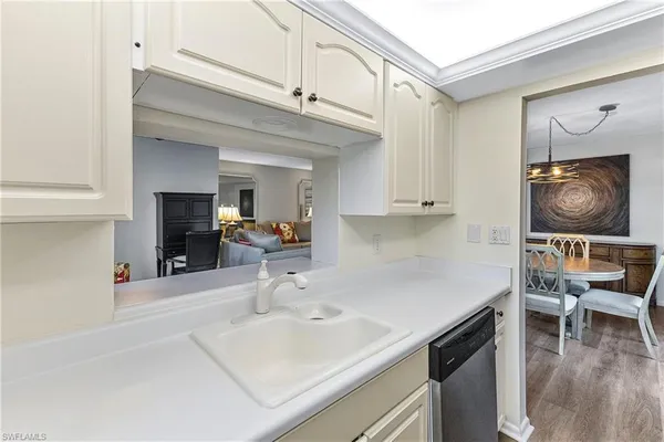 a kitchen with a sink cabinets and wooden floor