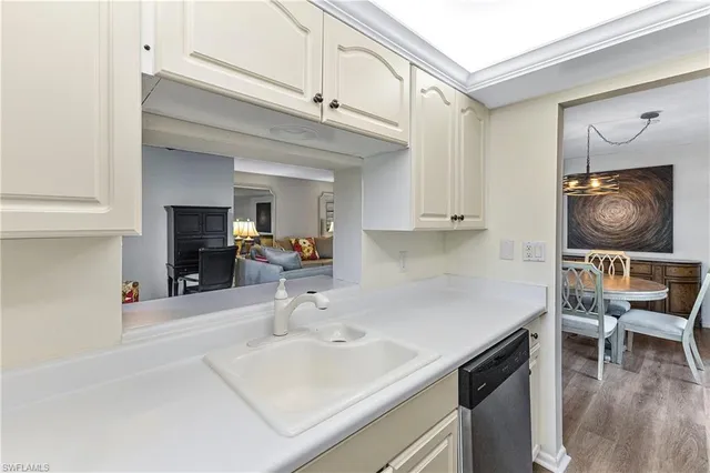 a kitchen with a sink cabinets and wooden floor