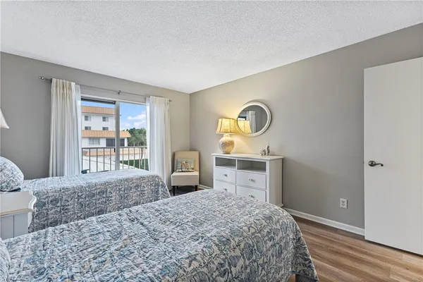 a bedroom with a bed and a dresser next to a window
