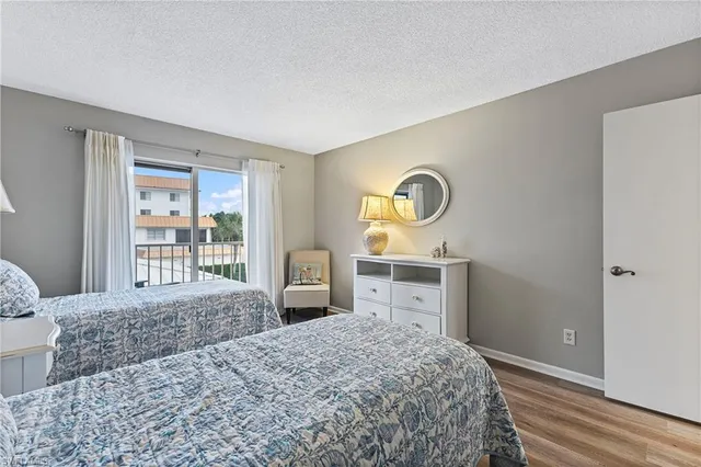 a bedroom with a bed and a dresser next to a window