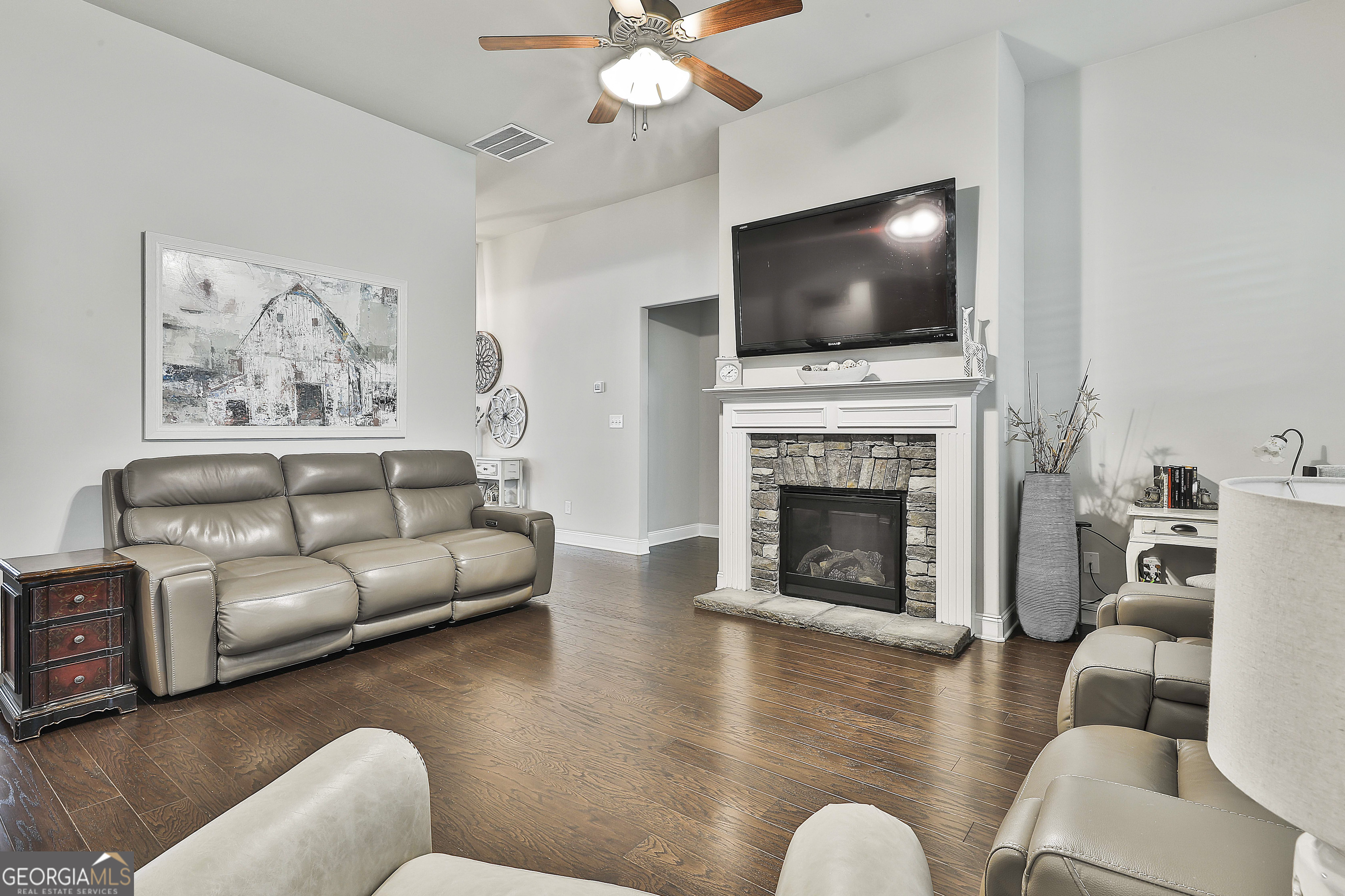 155 Wet Stone Road Senoia, GA 30276 - Photo 11 of 46 a living room with furniture a flat screen tv and a fireplace