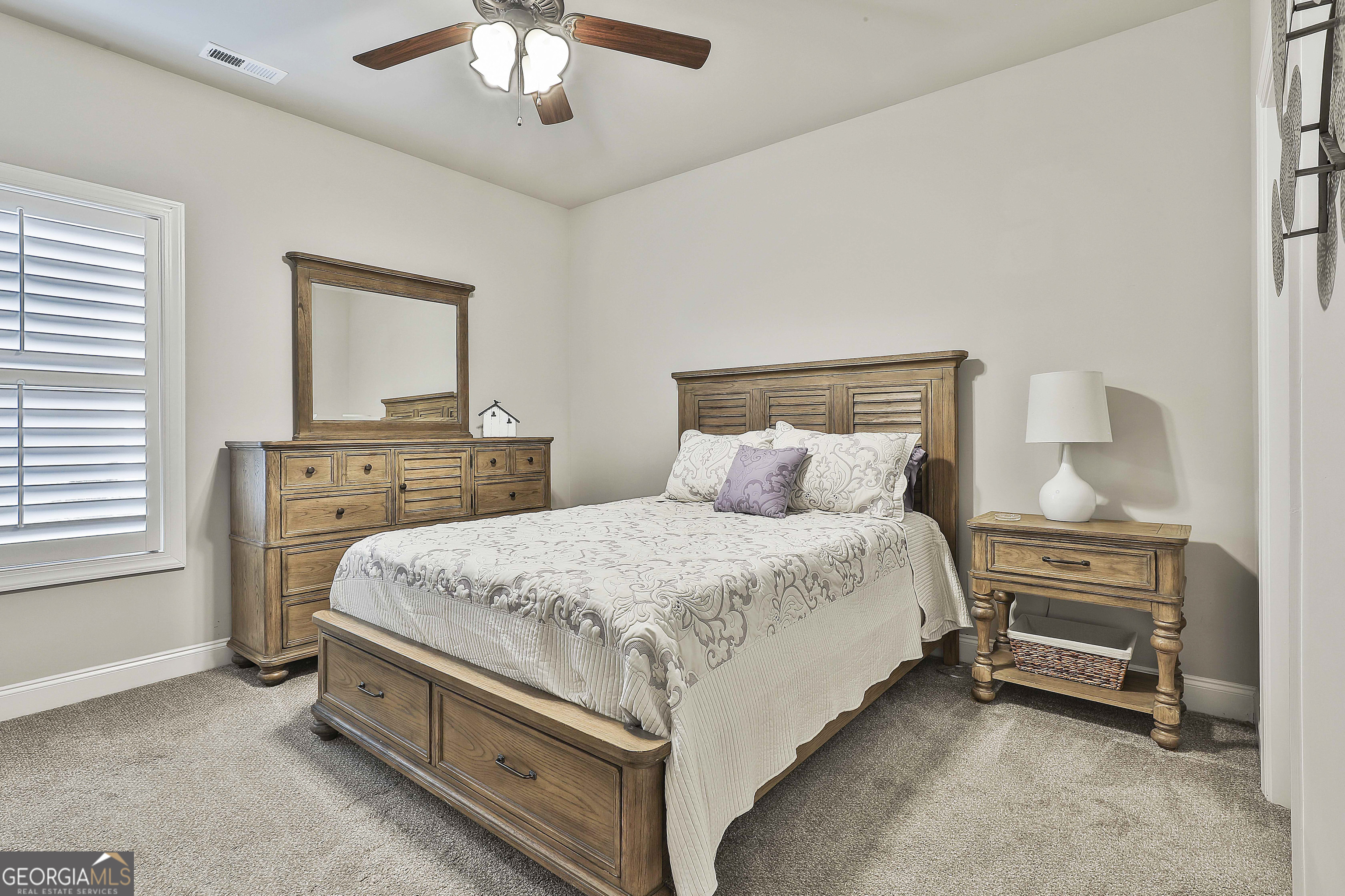 155 Wet Stone Road Senoia, GA 30276 - Photo 33 of 46 a spacious bedroom with a bed and a chandelier