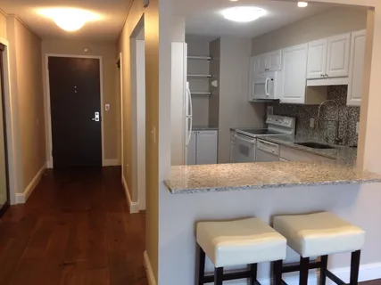 a kitchen with granite countertop a sink cabinets and refrigerator