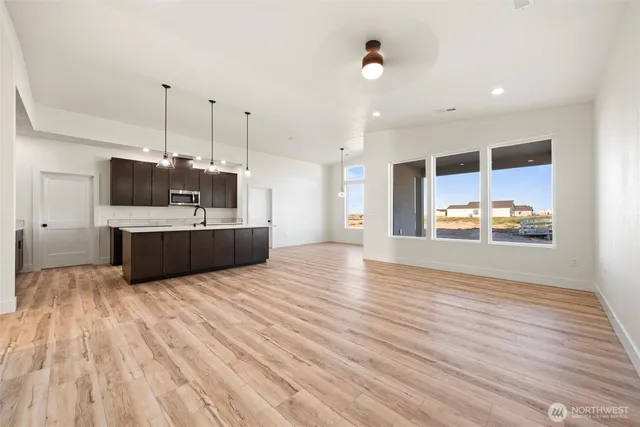 a large white kitchen with a stove and a wooden floor