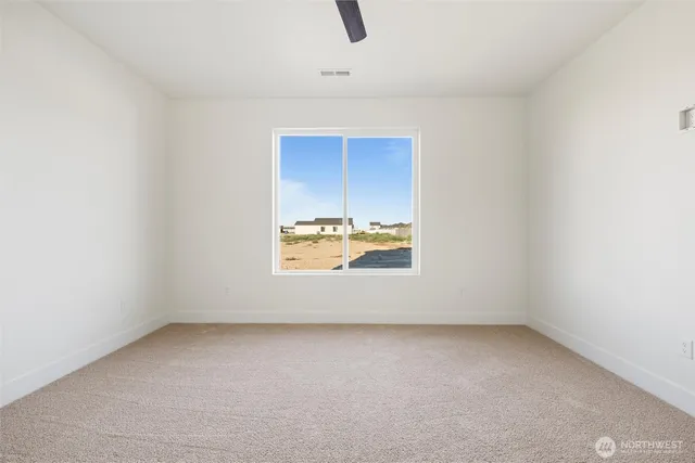 an empty room with a ceiling fan and window