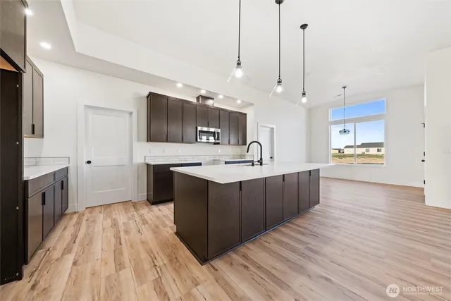 a kitchen with stainless steel appliances granite countertop a sink wooden cabinets and granite counter tops