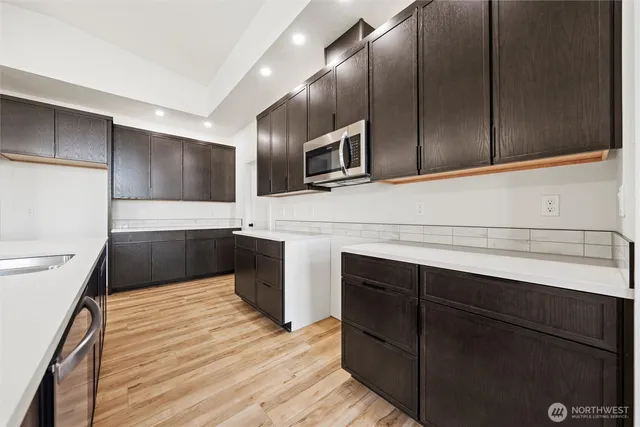 a large kitchen with kitchen island a sink stainless steel appliances and cabinets