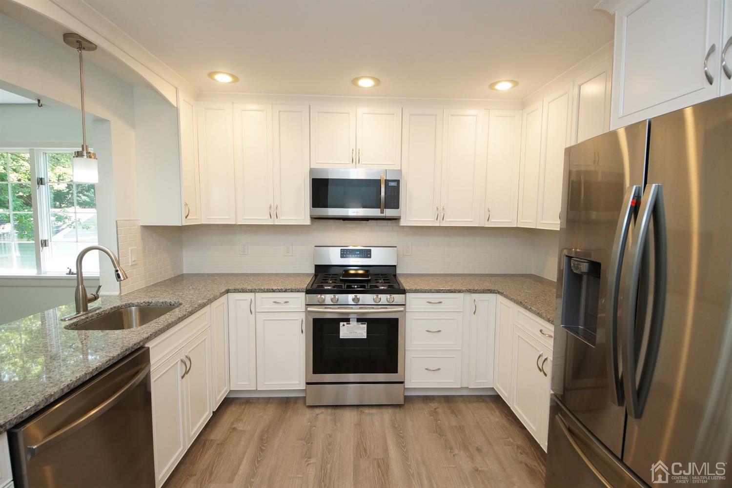238 New Road Monmouth Junction, NJ 08852 - Photo 19 of 63 a kitchen with stainless steel appliances granite countertop a stove top oven a sink and a refrigerator