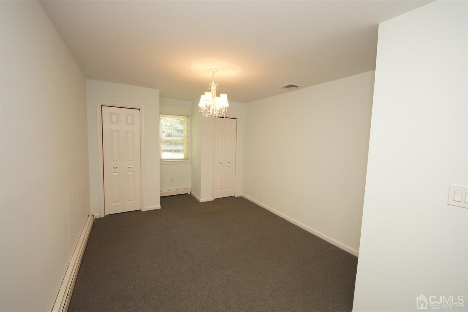 238 New Road Monmouth Junction, NJ 08852 - Photo 29 of 63 an empty room with wooden floor and mirror