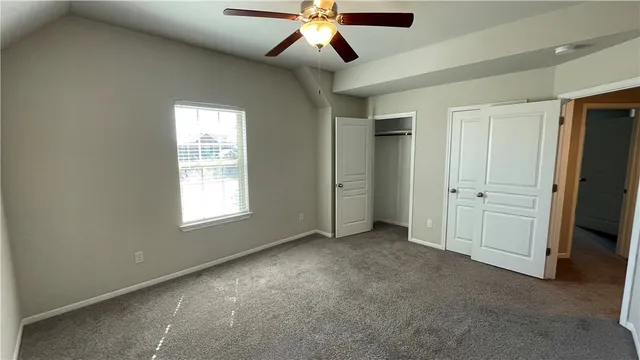 an empty room with closet and windows