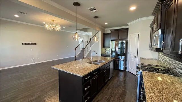 a kitchen with kitchen island a counter top space appliances and a ceiling fan