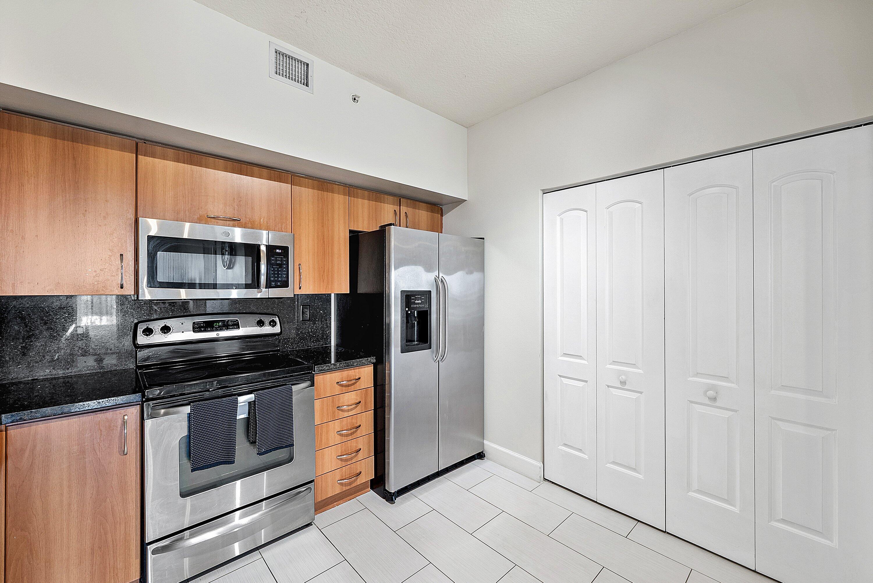 255 Northeast 3rd Avenue, Unit 2503 Delray Beach, FL 33444 - Photo 12 of 27 a kitchen with stainless steel appliances a refrigerator stove and microwave