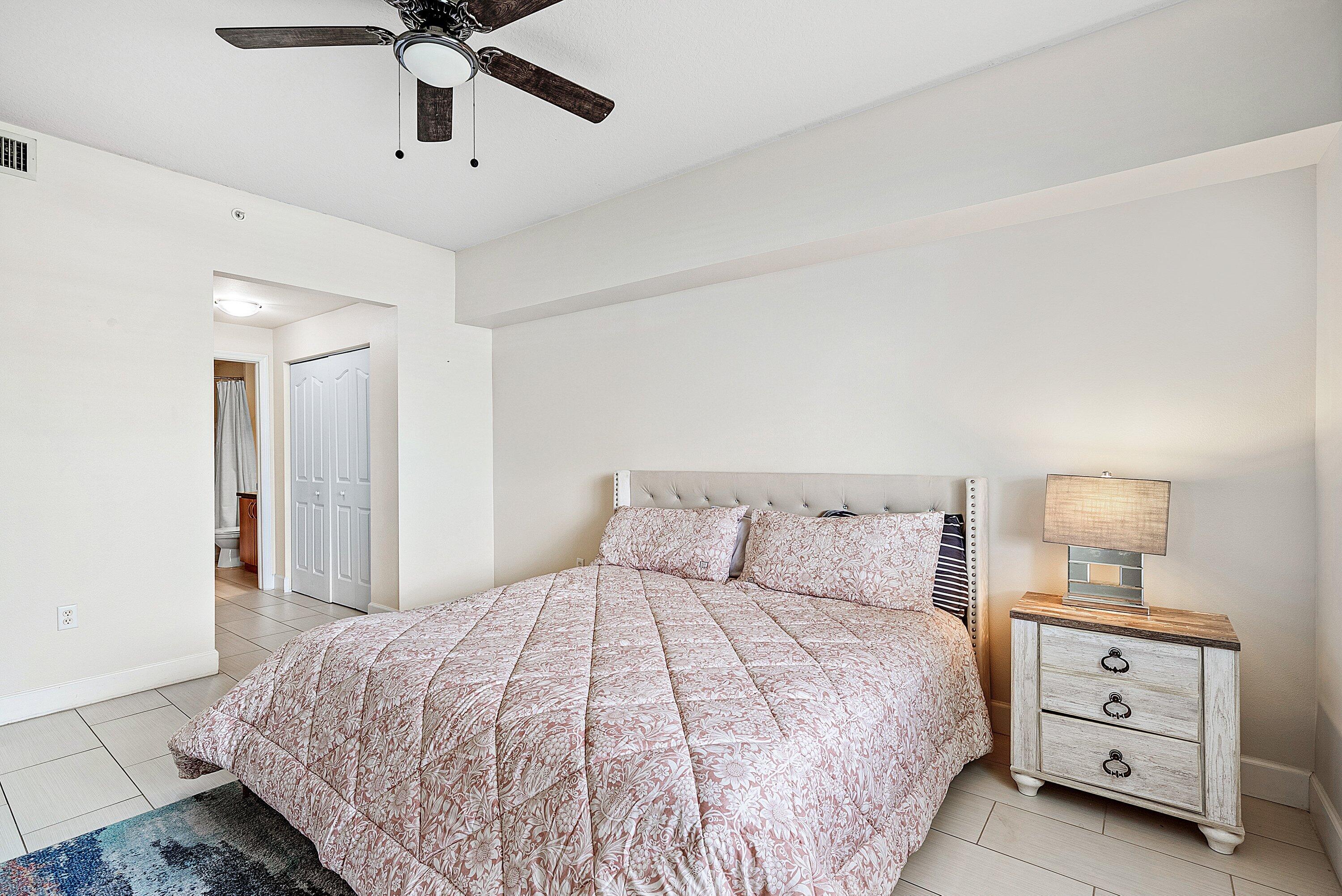 255 Northeast 3rd Avenue, Unit 2503 Delray Beach, FL 33444 - Photo 14 of 27 a bedroom with a bed and a chandelier