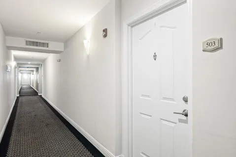 a view of a hallway with wooden floor