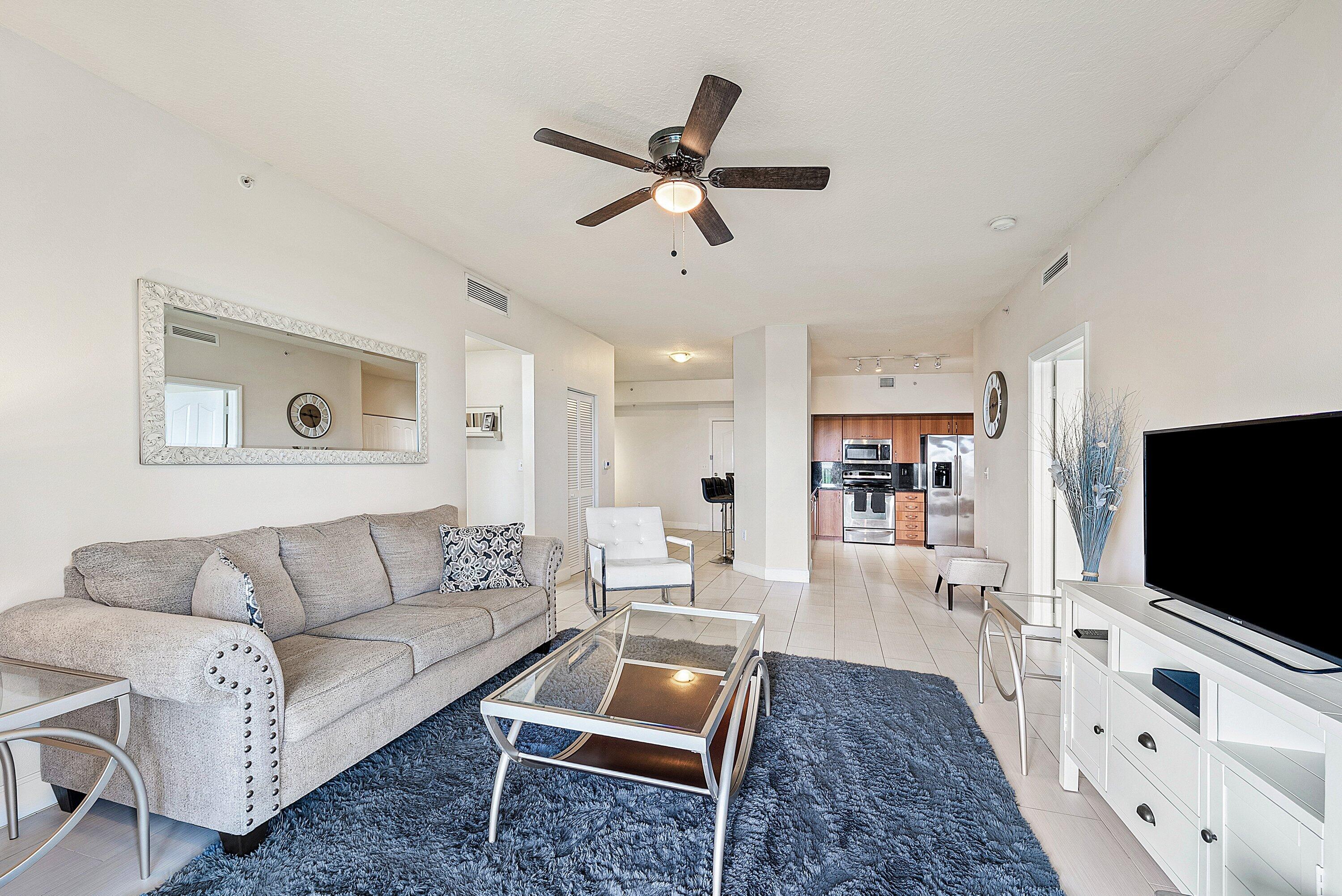 255 Northeast 3rd Avenue, Unit 2503 Delray Beach, FL 33444 - Photo 6 of 27 a living room with furniture and a flat screen tv