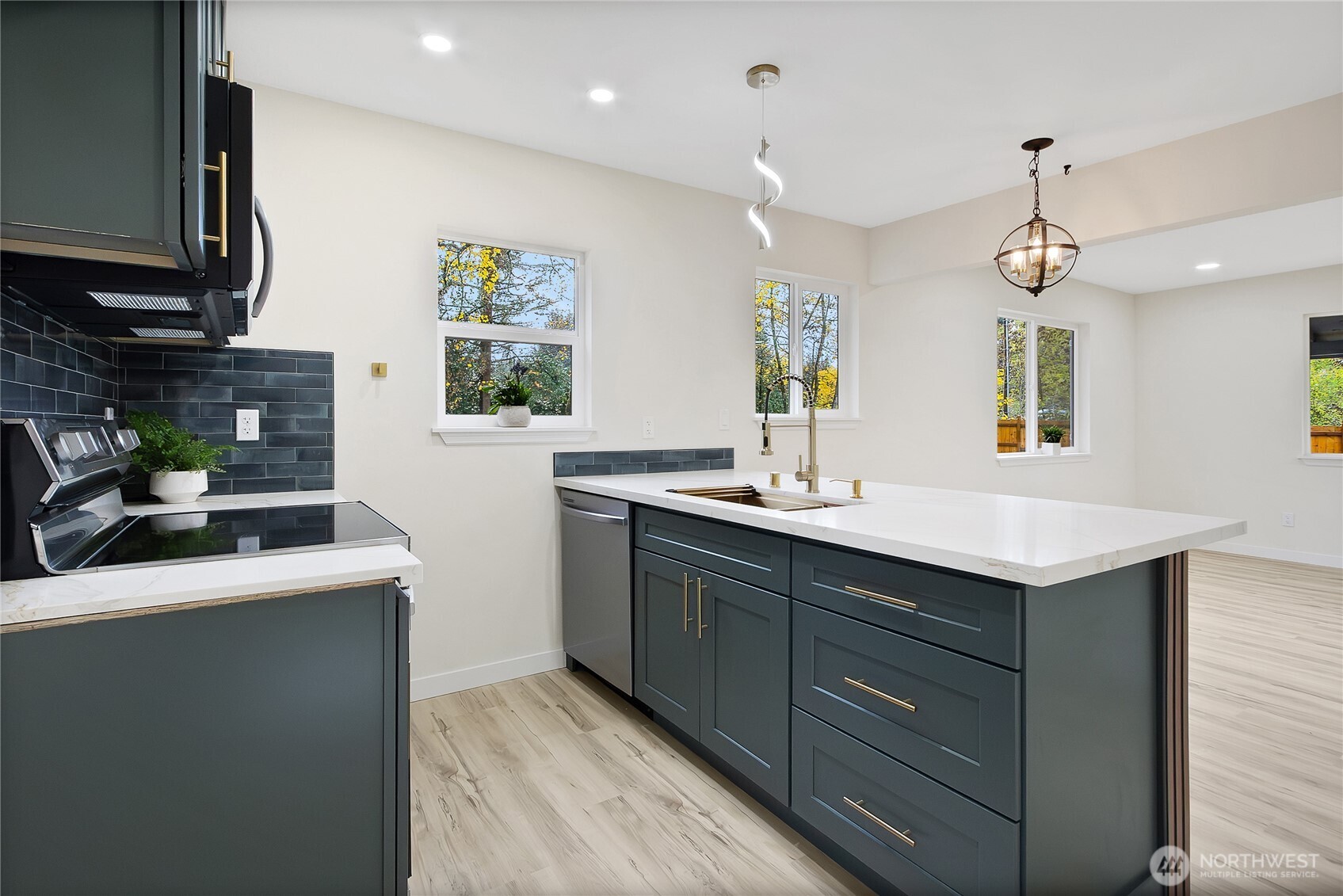 99 Sumner Avenue Sumner, WA 98390 - Photo 11 of 27 a kitchen with kitchen island granite countertop a sink stainless steel appliances and a counter top space