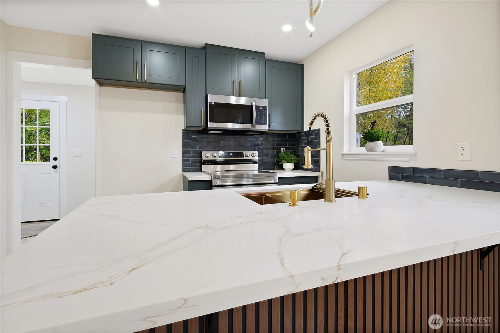 99 Sumner Avenue Sumner, WA 98390 - Photo 8 of 27 a kitchen with a refrigerator a stove and a sink with wooden floor