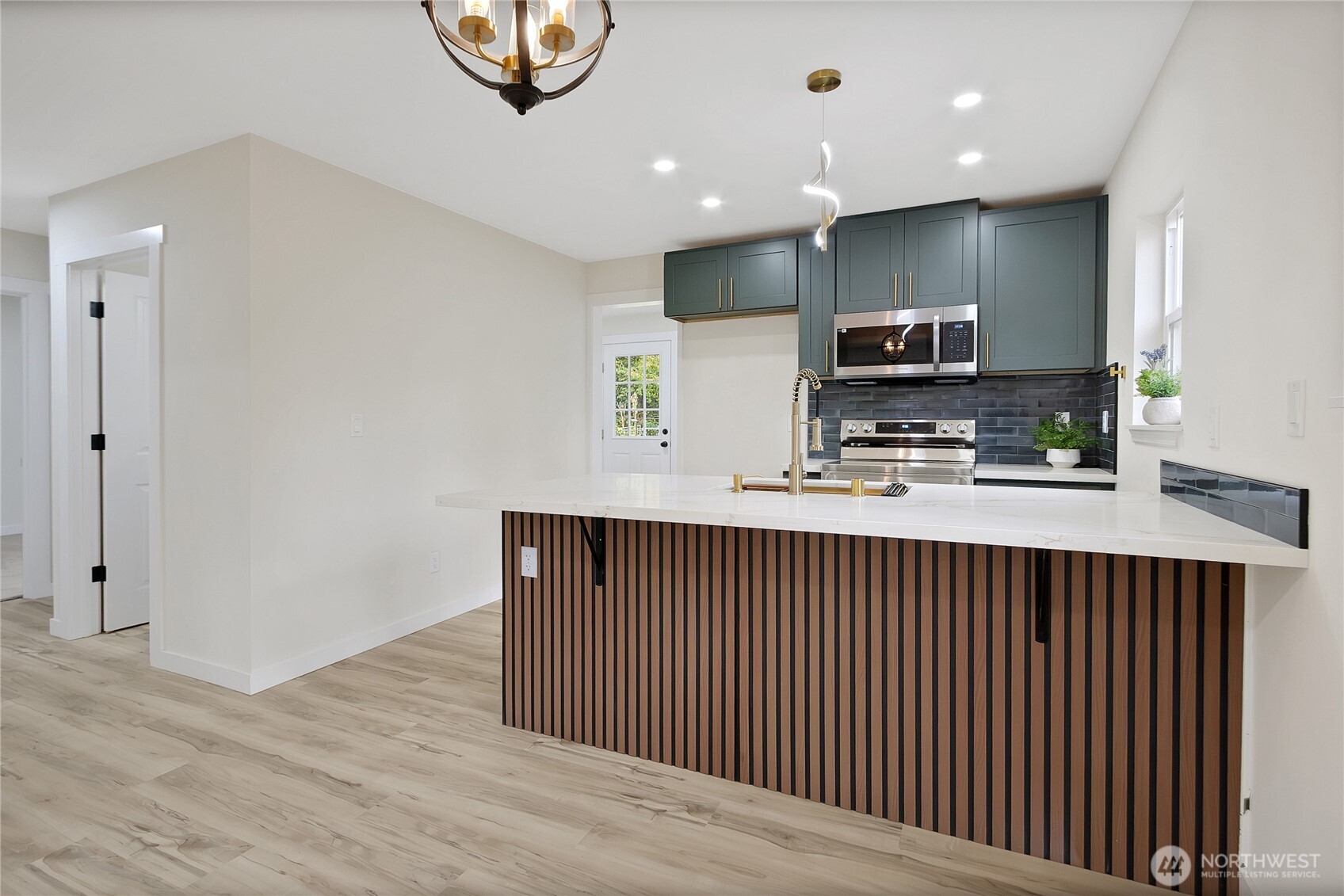 99 Sumner Avenue Sumner, WA 98390 - Photo 9 of 27 a kitchen with kitchen island microwave and cabinets
