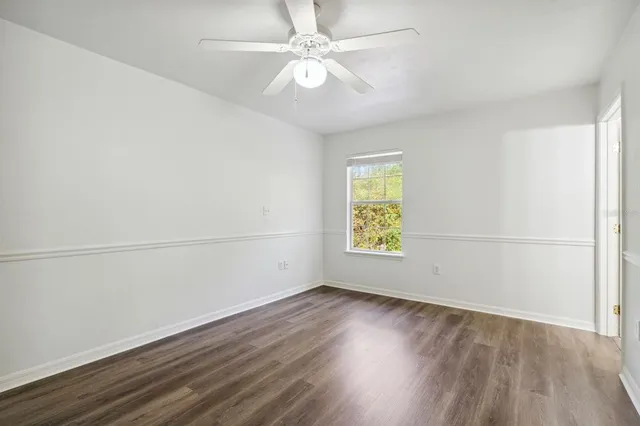 an empty room with a window and a ceiling fan