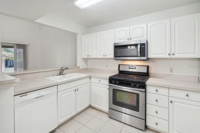 a kitchen with white cabinets and stainless steel appliances