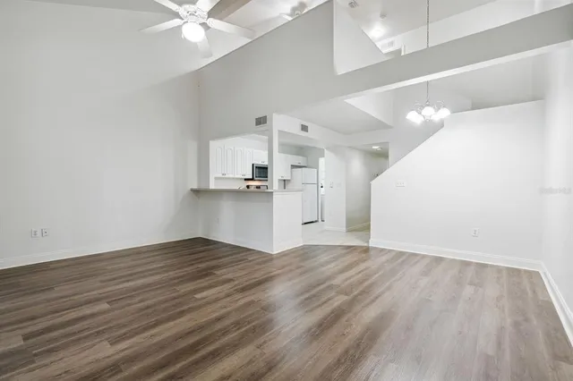 a view of a kitchen with wooden floor and a ceiling fan