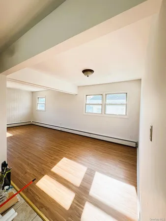 a view of a room with wooden floor and white walls