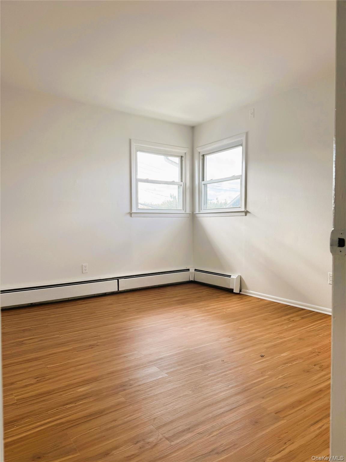 131 Roslyn Road, Unit 1 Mineola, NY 11501 - Photo 11 of 17 an empty room with wooden floor and a window